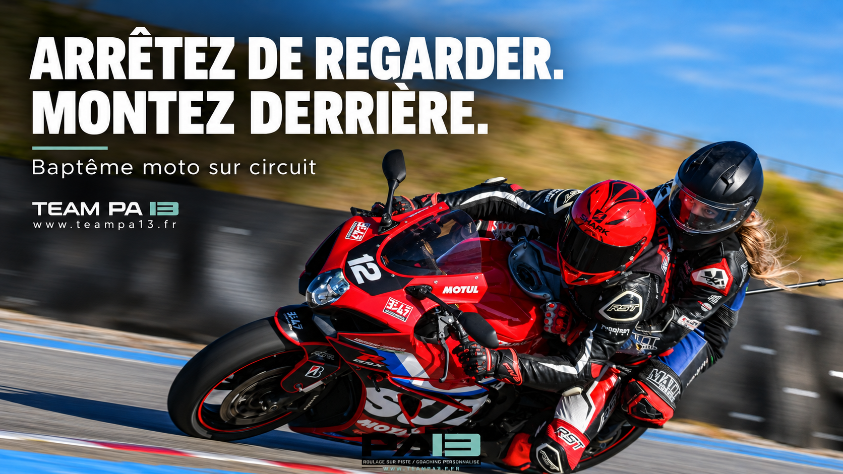 Pilote et passagère sur une moto rouge inclinée en virage sur circuit — baptême moto TEAM PA 13.